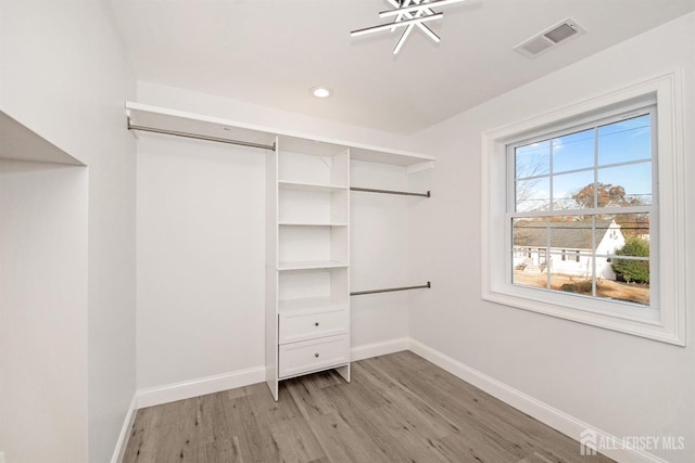 spacious closet featuring light wood-style flooring and visible vents