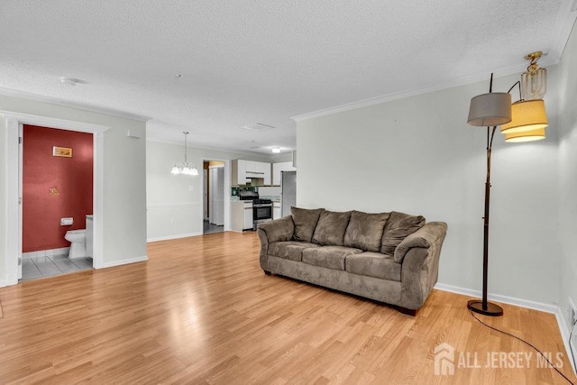 living room featuring ornamental molding, a textured ceiling, and light hardwood / wood-style floors