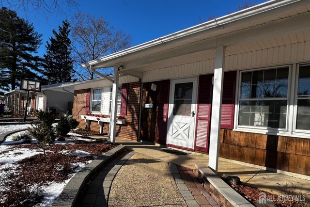 snow covered property entrance featuring a porch