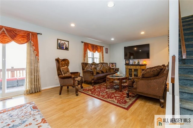 living area with stairway, recessed lighting, wood finished floors, and visible vents