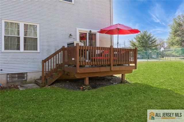 wooden terrace featuring fence and a yard