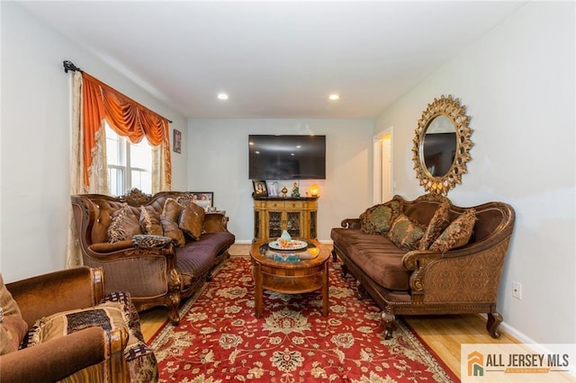 living area with recessed lighting, wood finished floors, and baseboards