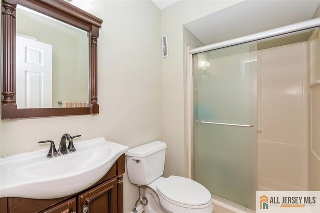 full bath with toilet, visible vents, a shower stall, and vanity