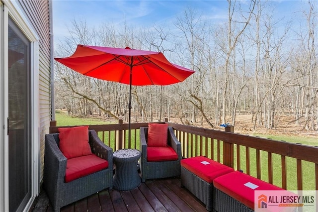 wooden terrace with a lawn and a wooded view