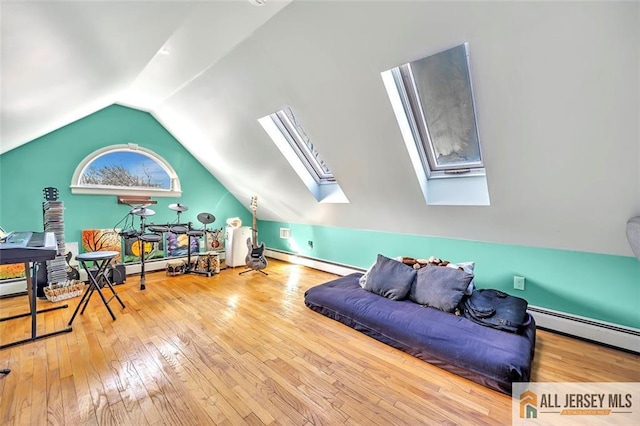 bonus room featuring lofted ceiling with skylight, baseboard heating, and wood finished floors