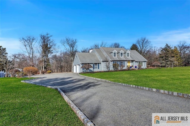 view of front of house with an attached garage, aphalt driveway, and a front yard