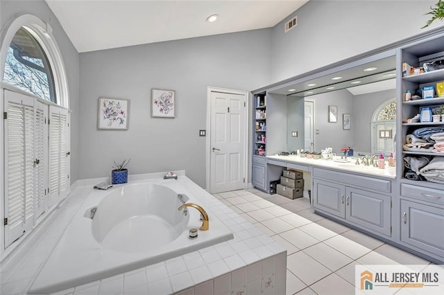 full bathroom with visible vents, tile patterned floors, a garden tub, vanity, and a closet