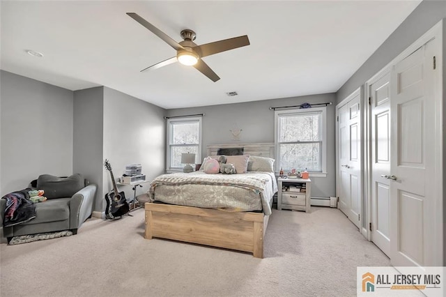 bedroom with light carpet, visible vents, a baseboard radiator, and a ceiling fan