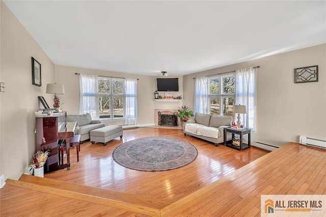 living room with a fireplace with flush hearth, a baseboard radiator, and wood finished floors