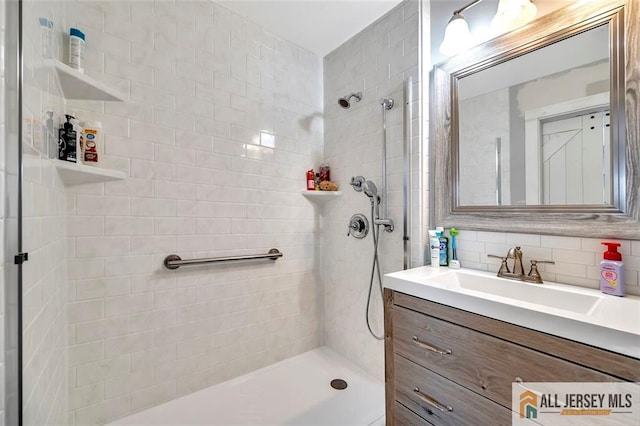 full bathroom featuring decorative backsplash, tiled shower, and vanity