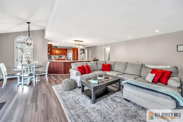 living area with recessed lighting, light wood-style flooring, and a notable chandelier