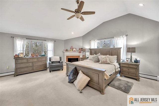 bedroom with light colored carpet, baseboard heating, a ceiling fan, a brick fireplace, and vaulted ceiling