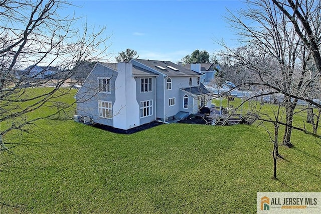 view of side of property with a lawn and a chimney