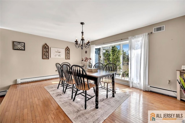 dining space with baseboard heating, an inviting chandelier, visible vents, and light wood-style floors