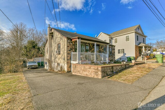 view of front of home with a porch and cooling unit