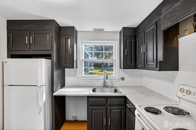 203 Rossmoor Dr Unit C, Monroe, NJ 08831 - kitchen with white appliances, decorative backsplash, dark cabinets, light stone countertops, and light wood-type flooring