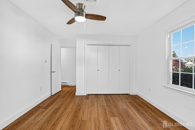 203 Rossmoor Dr Unit C, Monroe, NJ 08831 - unfurnished bedroom with wood finished floors, a baseboard heating unit, a closet, and ceiling fan