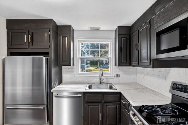 203 Rossmoor Dr Unit C, Monroe, NJ 08831 - kitchen with stainless steel appliances, tasteful backsplash, dark cabinets, and light stone countertops