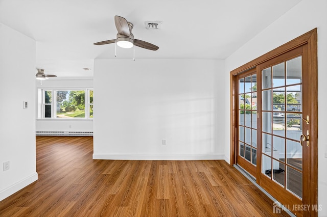 203 Rossmoor Dr Unit C, Monroe, NJ 08831 - empty room featuring a baseboard heating unit, wood finished floors, and healthy amount of natural light