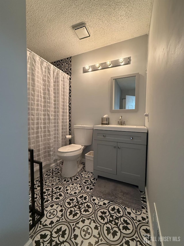 bathroom featuring toilet, vanity, a shower with curtain, and a textured ceiling