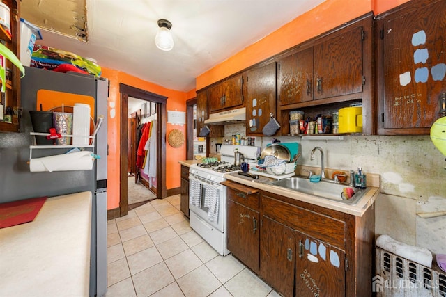 11 Jean Ct, Woodbridge Proper, NJ 07095 - kitchen featuring white gas range oven, under cabinet range hood, a sink, light countertops, and light tile patterned flooring