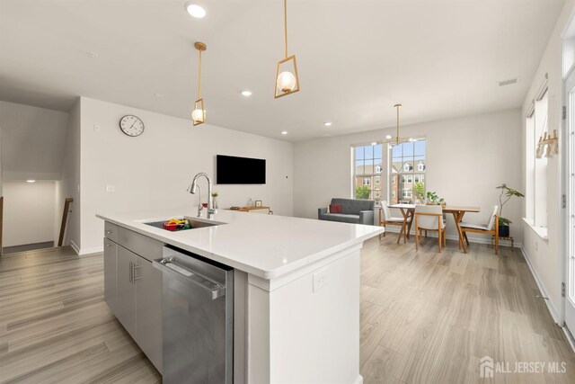 4 Arnold Dr Unit 5302, Wood-Ridge, NJ 07075 - kitchen with dishwasher, light wood-type flooring, light countertops, a kitchen island with sink, and decorative light fixtures