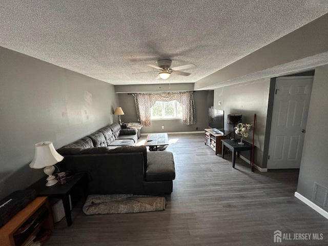 living room featuring baseboards, wood finished floors, visible vents, and a ceiling fan