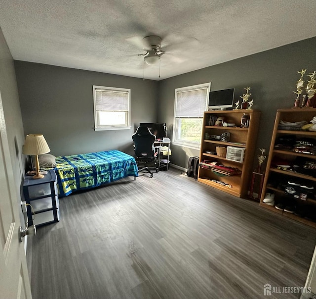 bedroom featuring ceiling fan, a textured ceiling, and wood finished floors