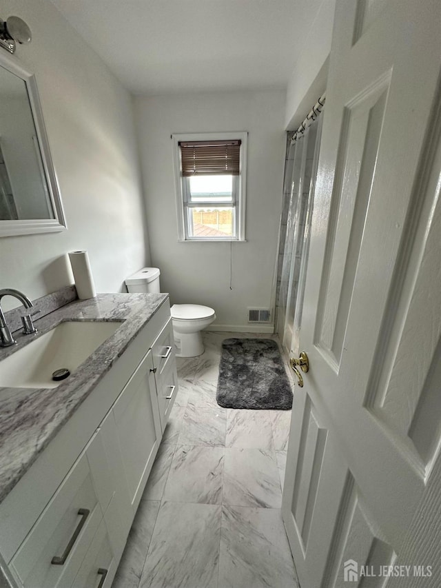 bathroom with visible vents, toilet, marble finish floor, walk in shower, and vanity