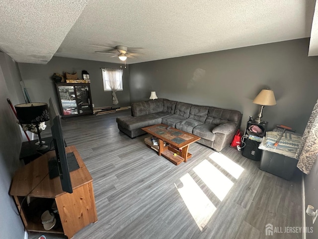 living area with a textured ceiling, a baseboard radiator, wood finished floors, and a ceiling fan