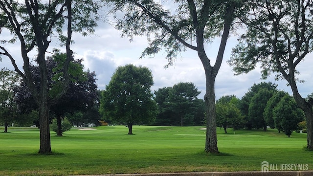 view of property's community with a yard and view of golf course