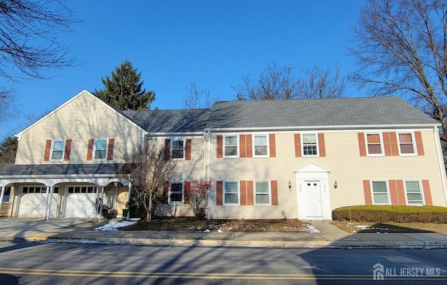 townhome / multi-family property with concrete driveway and a garage