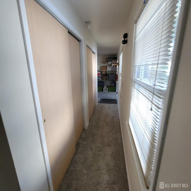 corridor with dark carpet and plenty of natural light