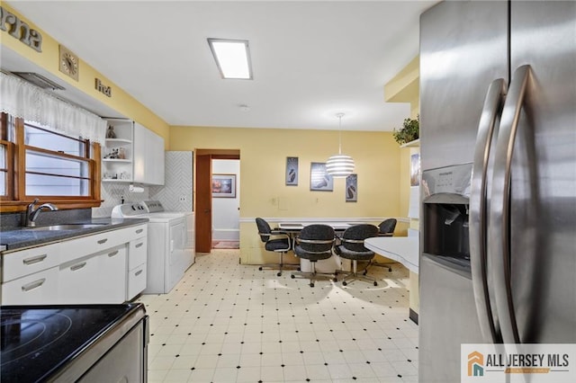 377 Ridge Rd, South Brunswick, NJ 08810 - kitchen featuring stainless steel fridge, washing machine and dryer, white cabinets, and dark countertops