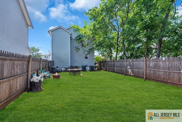 view of yard with a fire pit and central air condition unit