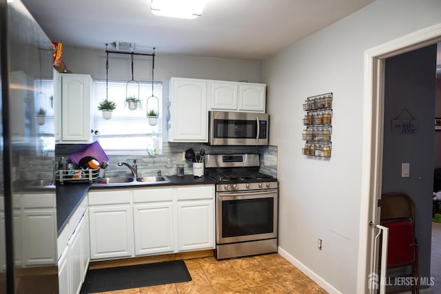 50 Heald St, Carteret, NJ 07008 - kitchen with appliances with stainless steel finishes, decorative backsplash, dark countertops, and white cabinetry