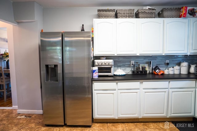 50 Heald St, Carteret, NJ 07008 - kitchen featuring stainless steel fridge, dark countertops, white cabinets, and backsplash