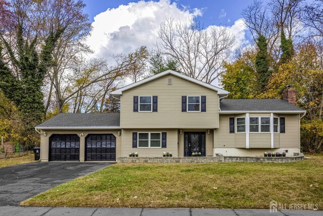 split level home featuring a front yard and a garage