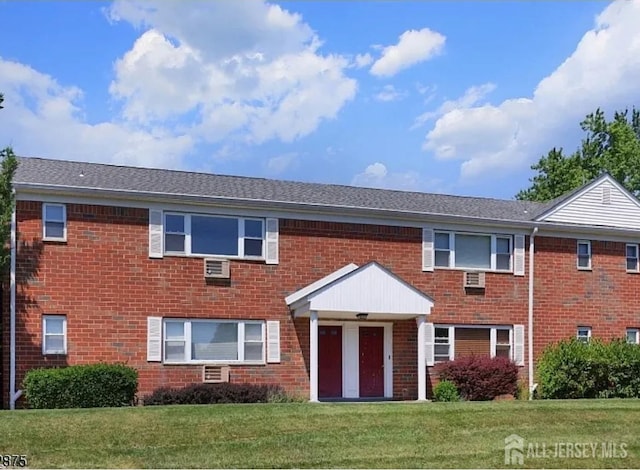 view of property featuring a front yard and brick siding