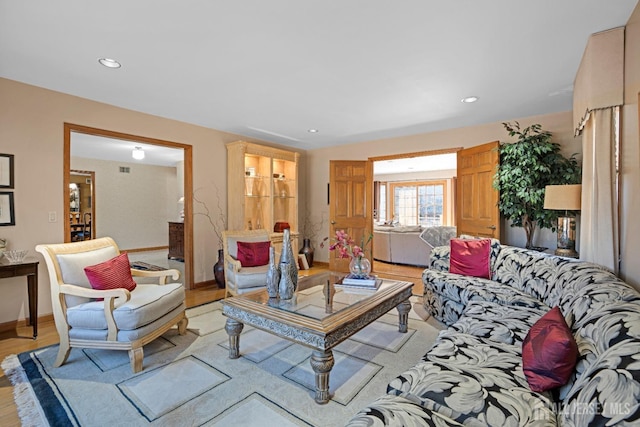 living area featuring light wood finished floors, recessed lighting, and baseboards