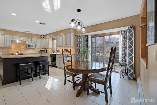 dining room with a toaster, a healthy amount of sunlight, visible vents, and light tile patterned floors