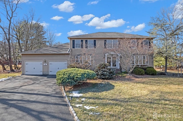 colonial home with a garage and a front lawn