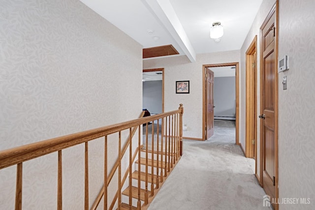 hallway featuring a baseboard heating unit, light carpet, an upstairs landing, beamed ceiling, and wallpapered walls