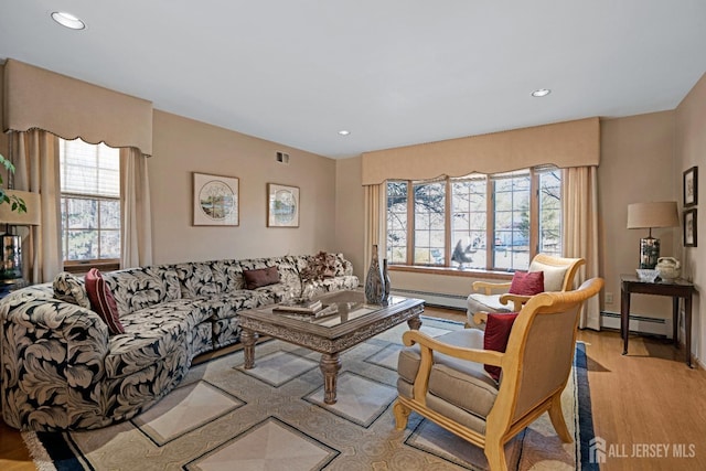 living area with light wood-style flooring, baseboard heating, visible vents, and recessed lighting