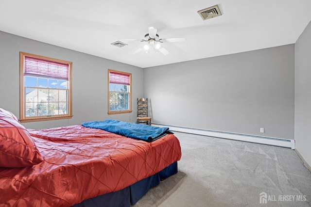 carpeted bedroom with baseboards, visible vents, baseboard heating, and a ceiling fan