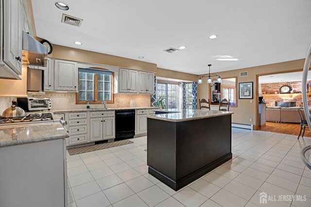 kitchen with black dishwasher, a center island, white cabinets, and decorative light fixtures