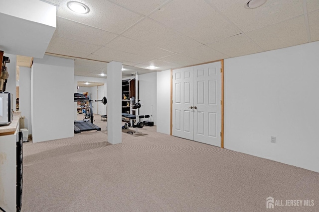 exercise area featuring carpet and a paneled ceiling