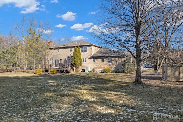 rear view of house with a yard and a deck