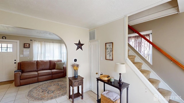 68 Applegate Ave, Monroe, NJ 08831 - living room featuring arched walkways, light tile patterned floors, stairway, a textured ceiling, and ornamental molding