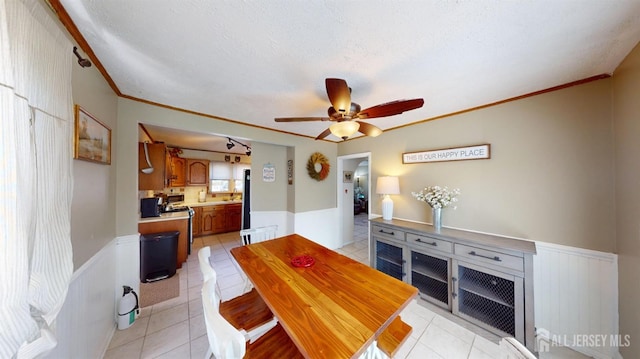 68 Applegate Ave, Monroe, NJ 08831 - dining room with light tile patterned flooring, crown molding, a ceiling fan, wainscoting, and a textured ceiling
